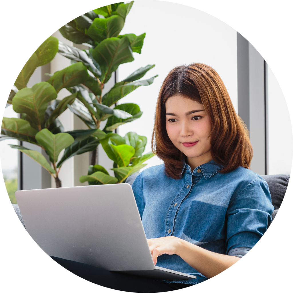 Woman sitting on sofa working on laptop