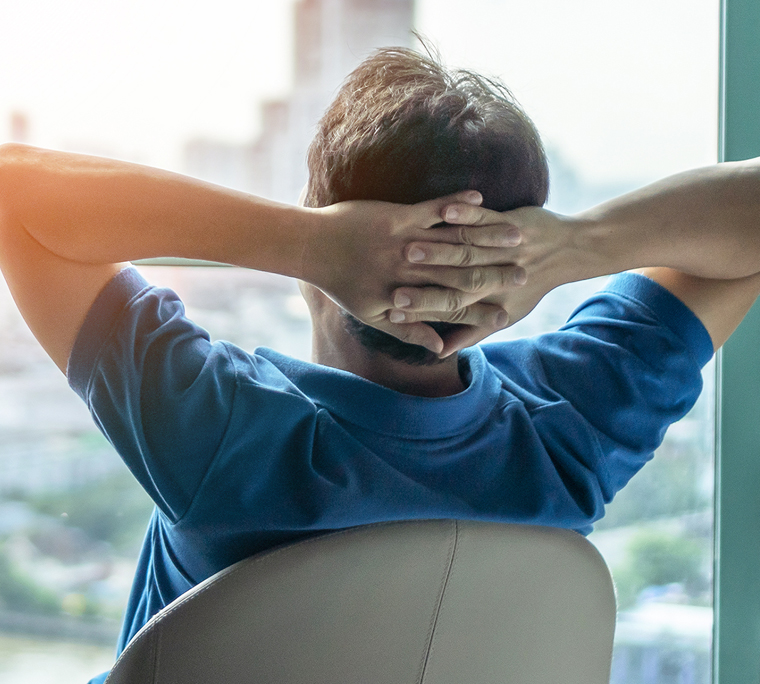 Businessman stretching in office chair