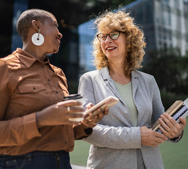 Two business women, one black and one white, having a conversation
