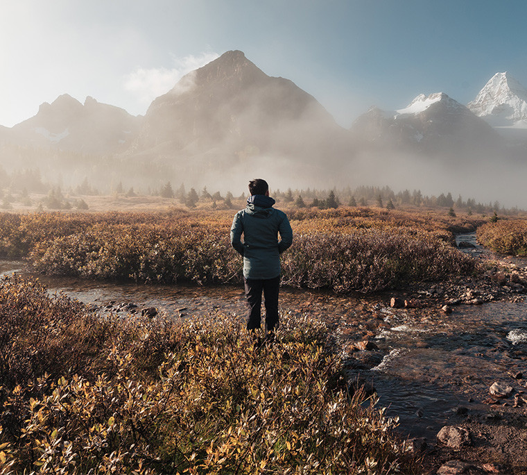 a man is going for a stroll in rocky mountain scene